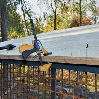 Bygga Vedförråd: En bottenlist sätts under takskivan Bygga Vedförråd